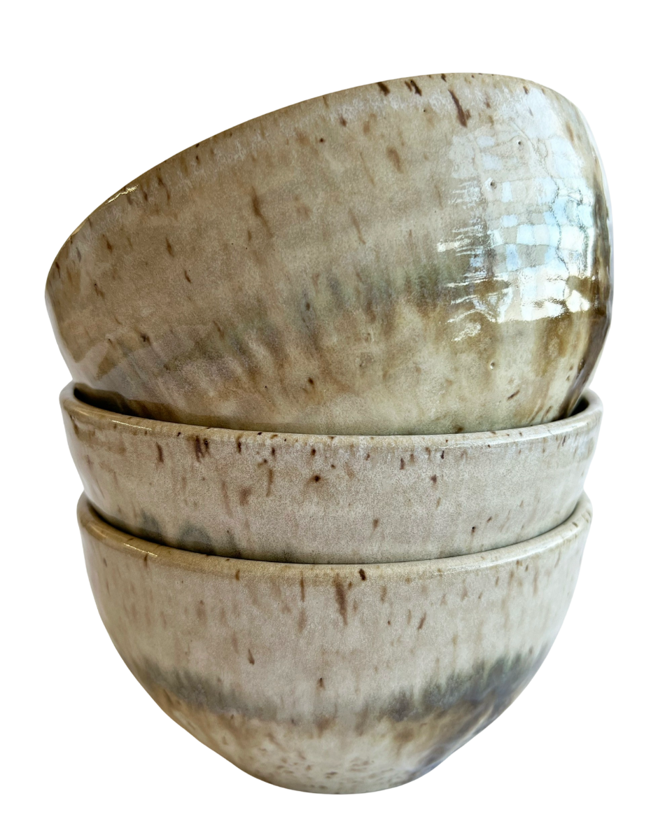 Stack of three ceramic bowls with light and dark neutral glaze details on a white background