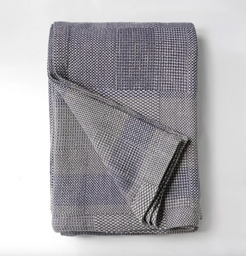 Folded textured blanket on a light gray background