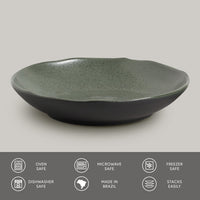 Green ceramic pasta plate on a gray background with safety and feature icons at the bottom.