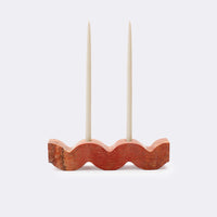 Orange stone wavy candle holder with two taper candles on a white background