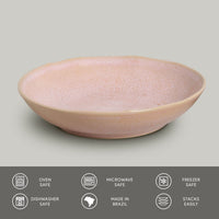 Pink ceramic pasta plate on a gray background with safety and feature icons at the bottom.