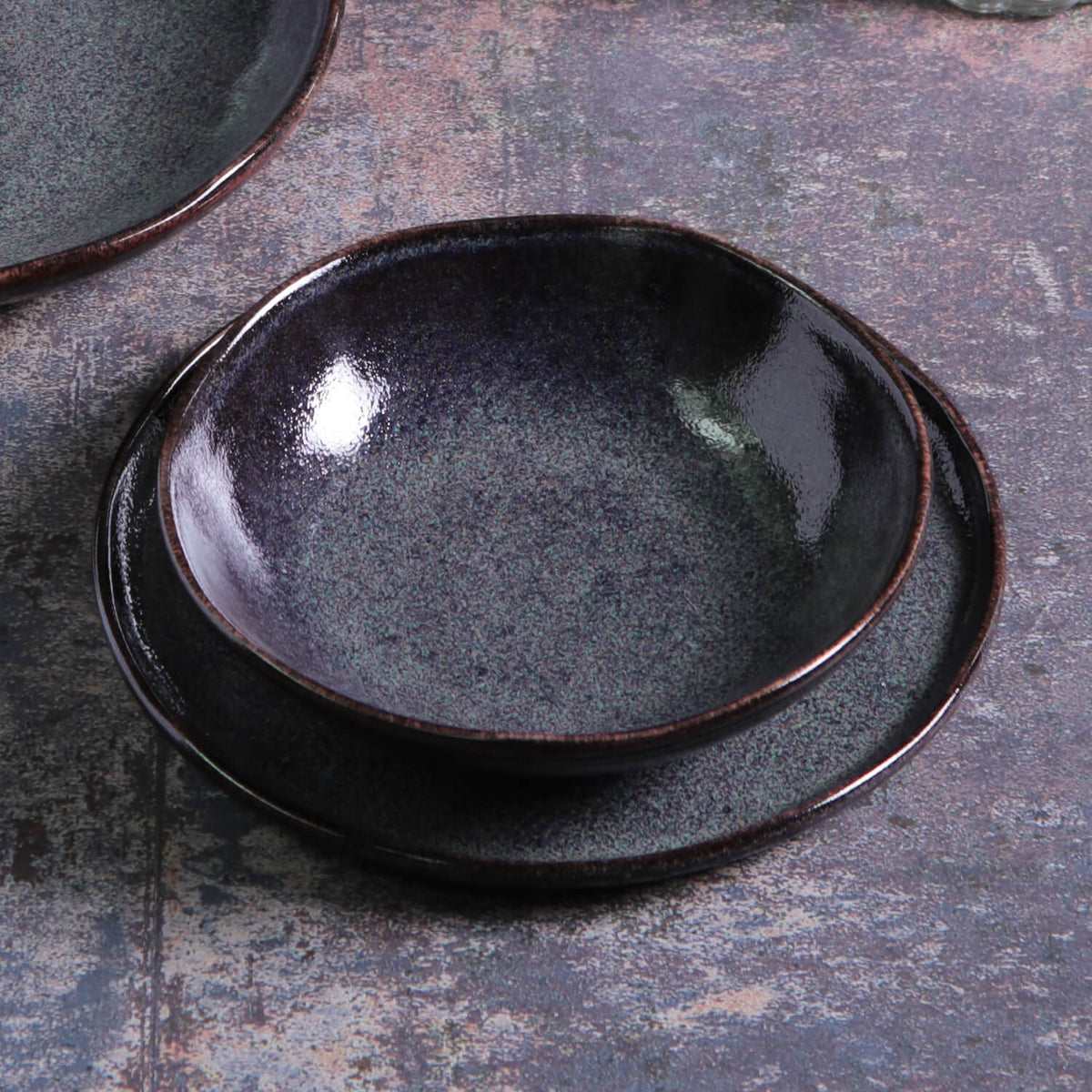 Set of black ceramic plates on a textured surface