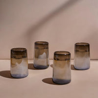 Four gradient glass tumblers on a neutral background