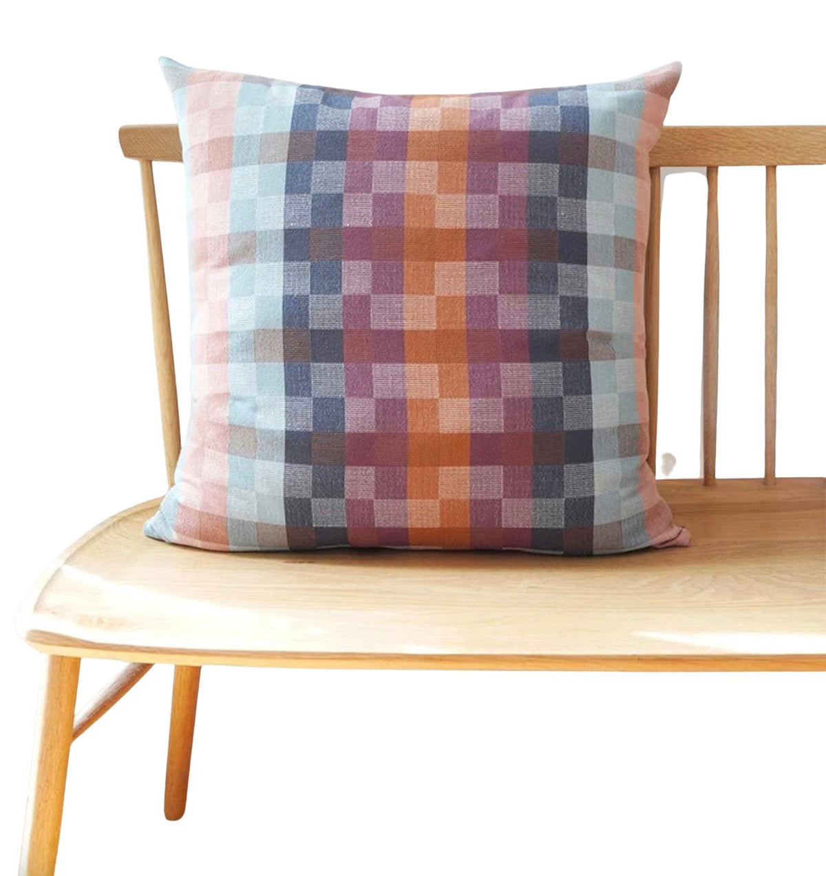 Plaid pillow on a wooden bench with a white background