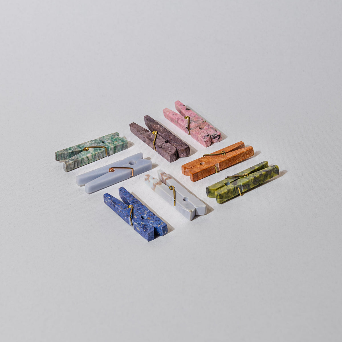 Colorful stone clothespins on a light gray background