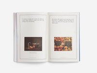 Open book with two pages showing still life paintings of apples and a bowl.