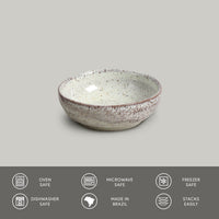 Speckled ceramic bowl on a gray background with safety and feature icons at the bottom.