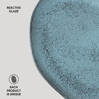 Blue ceramic plate with reactive glaze on a light gray background