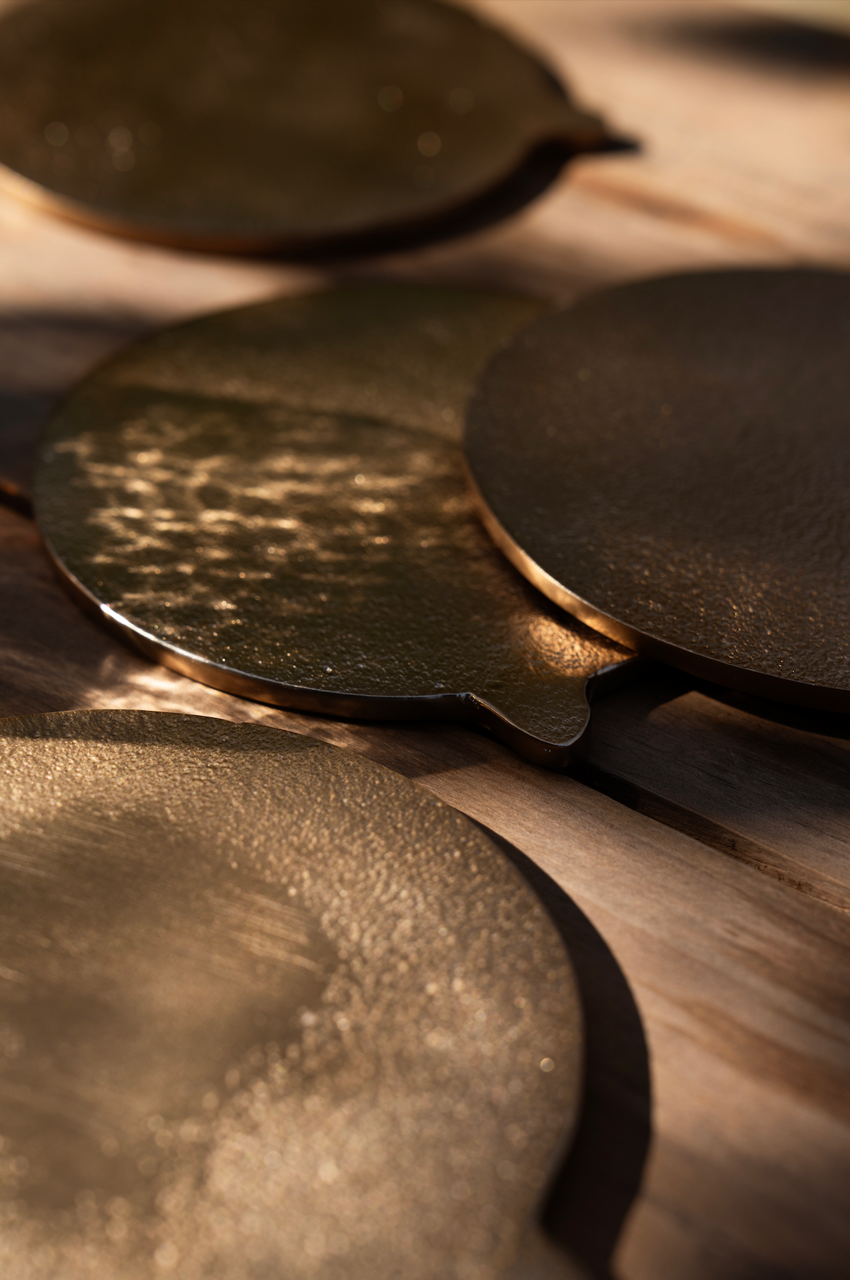 Close-up of brass coasters on a wooden surface