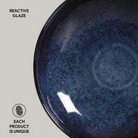 Blue ceramic plate with reactive glaze on a light gray background