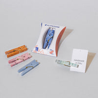 assortment of colorful stone clothespins with packaging and a card that says 'Handmade in Peru'