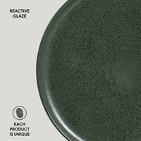 Green ceramic plate with reactive glaze texture on a light gray background