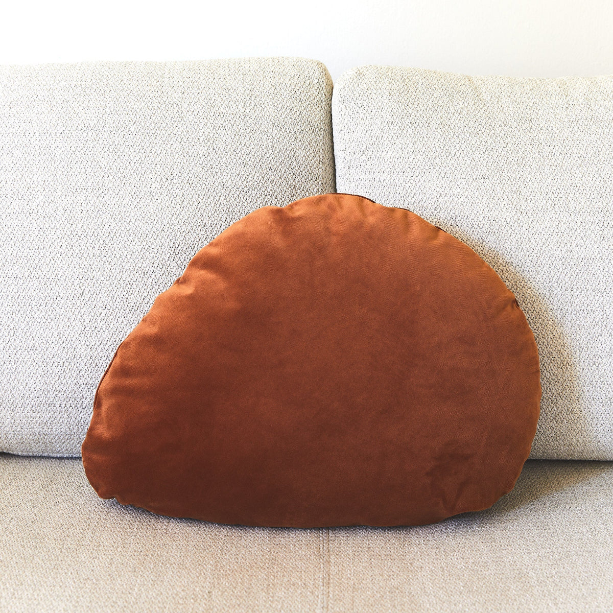 Brown velvet pillow on a beige sofa