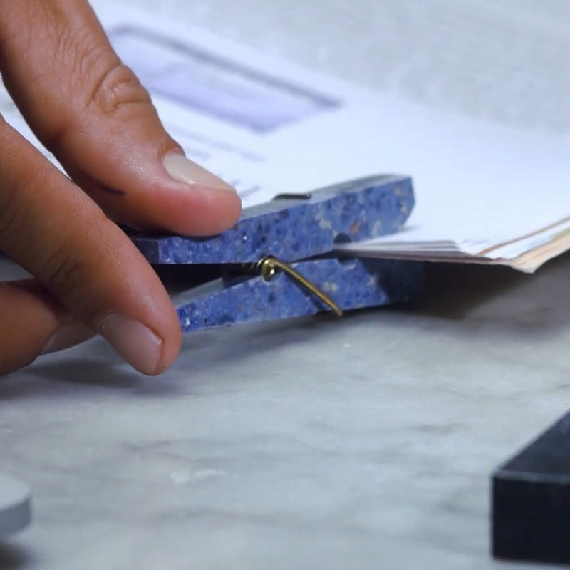 hand clipping mail togehter with a blue stone clothespin clip