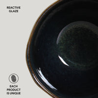 Ceramic bowl with reactive glaze on a light gray background