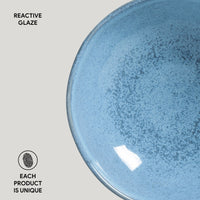 Blue ceramic plate with reactive glaze on a light gray background