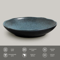 Blue ceramic pasta plate on a gray background with safety and feature icons at the bottom.