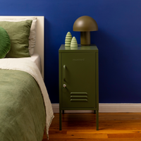 Green locker stylenightstand with decorative items next to a bed against a blue wall