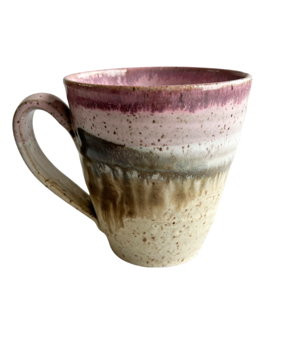 Ceramic mug with light and dark neutral and pink glaze details on a white background