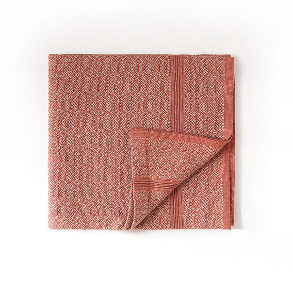 Folded red textured towel on a white background