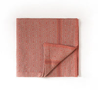 Folded red textured towel on a white background