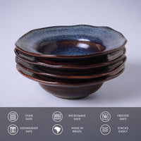 Stack of ceramic bowls with blue speckled top and brown base on a light gray background.