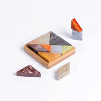 Wooden tangram puzzle with multicolored pieces on a white background