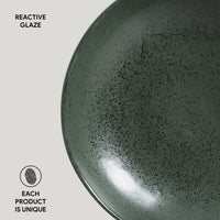 Green ceramic plate with reactive glaze on a light gray background