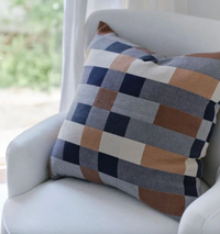 Checkered pillow on a white chair with a blurred background