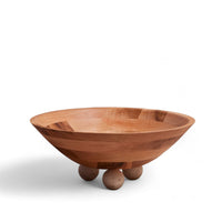 Wooden bowl with three spherical marble feet on a white background
