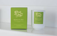 Candle and packaging of 'Electric Tides Soleil All Day' on a white background