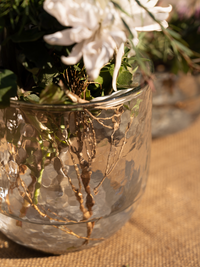 Decorative glass vase with floral arrangement on a textured surface