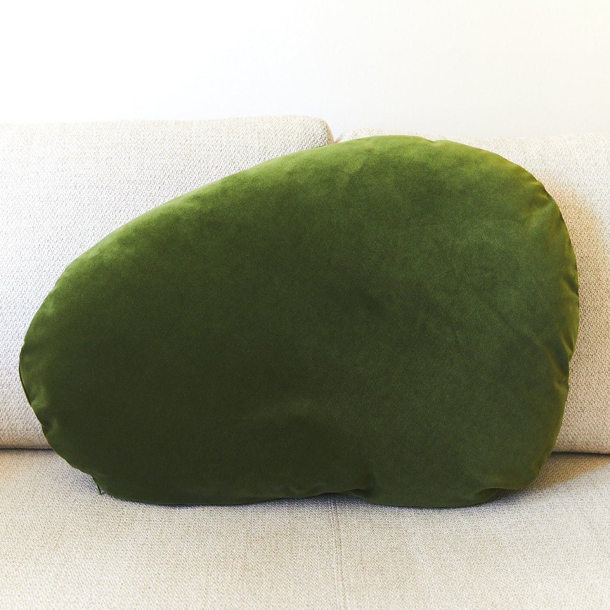 Green cushion on a beige sofa