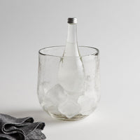 Clear glass ice bucket with bottle on a white background
