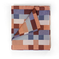 Folded checkered blanket with brown, blue, and beige squares