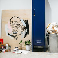 Art studio with abstract painting, blue locker, and art supplies.