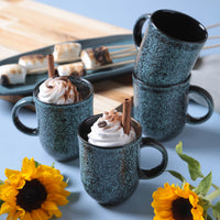 Speckled blue mugs with hot chocolate and whipped cream, sunflowers on a light blue background