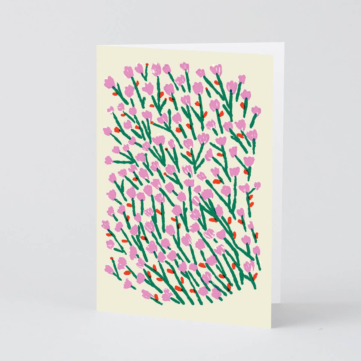 Card with pink and green floral pattern on a beige background