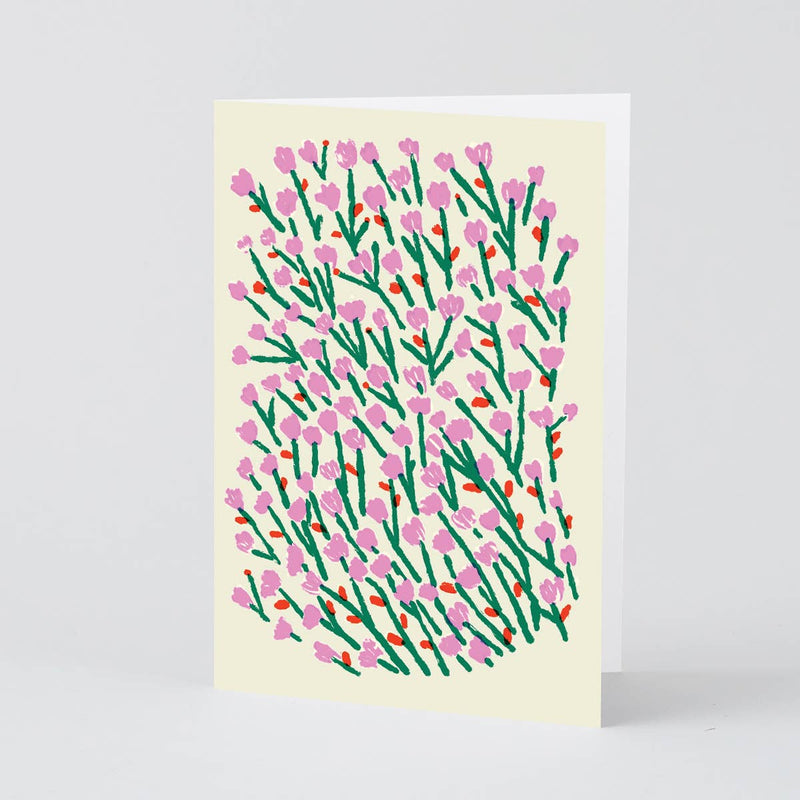 Card with pink and green floral pattern on a beige background