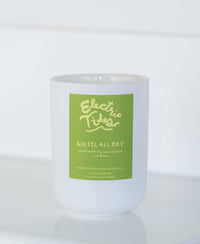 Frosted candle with a green label on a white background