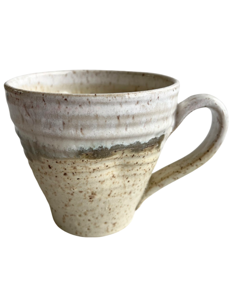 Ceramic mug with light and dark neutral glaze details on a white background