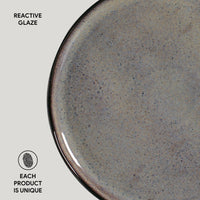 Close-up of a ceramic plate with reactive glaze on a light gray background