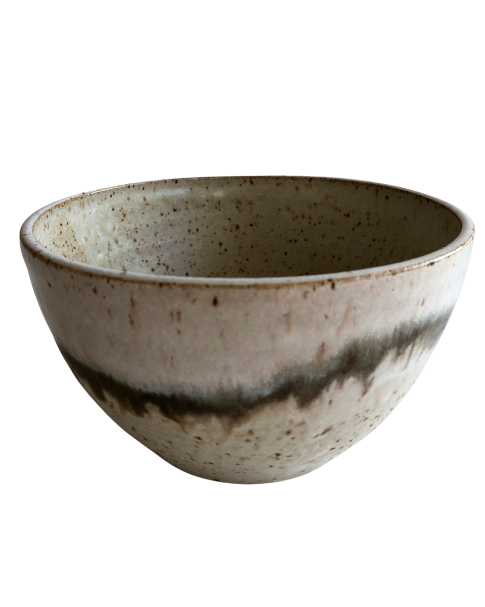 Ceramic bowl with light and dark neutral glaze details on a white background