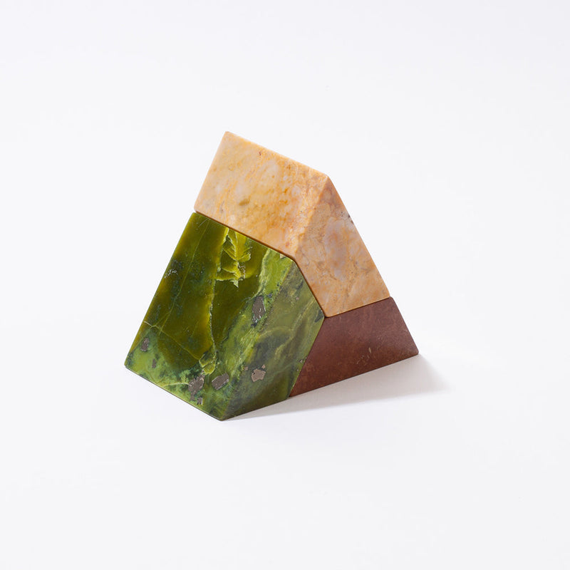 Triangular stone with green and brown colors on a white background