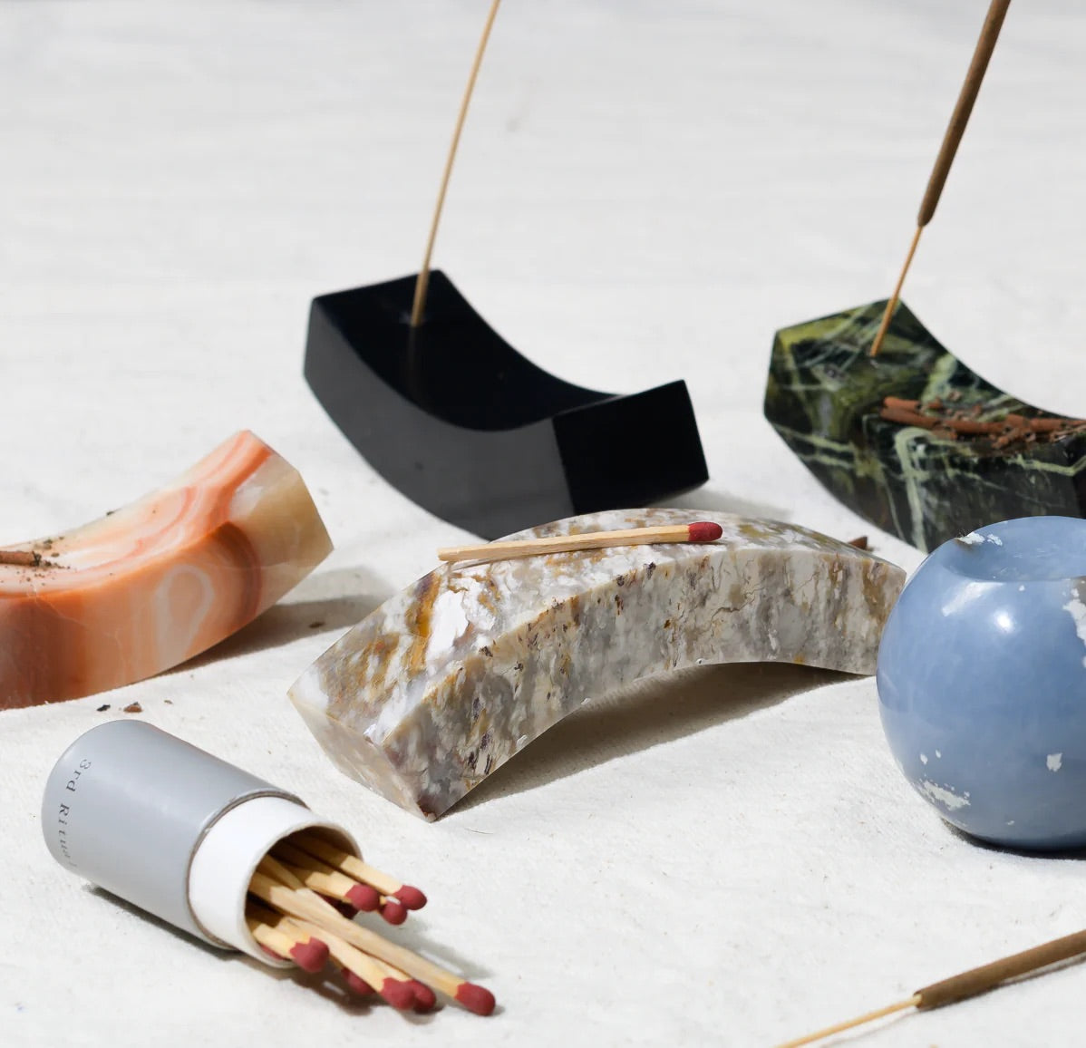 Incense sticks and stone holders with matches on a light background