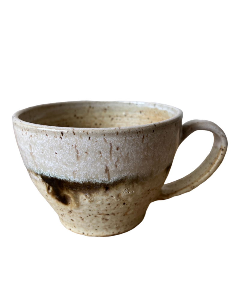Ceramic mug with light and dark neutral glaze details on a white background