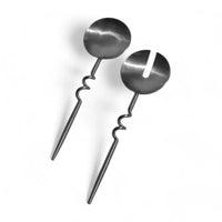 Pair of metal serving spoons on a white background