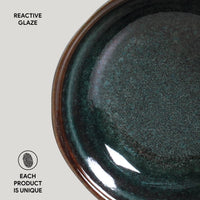 Close-up of a ceramic bowl with reactive glaze on a light gray background