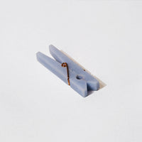 A light blue stone clothespin on a light grey background