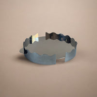 stainless steel round squiggle tray on a tan background